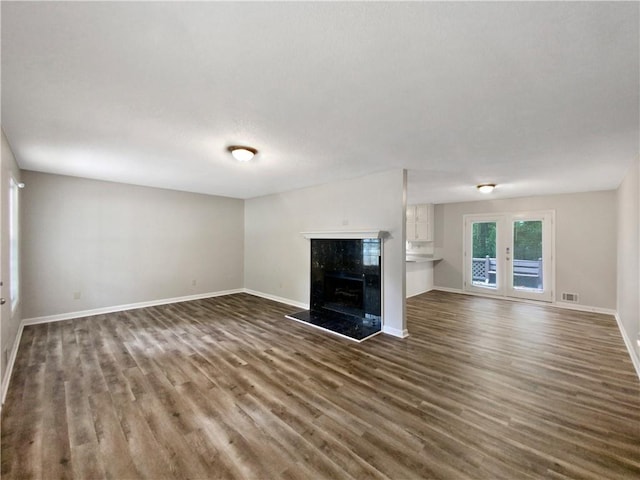 unfurnished living room featuring dark hardwood / wood-style flooring and a fireplace