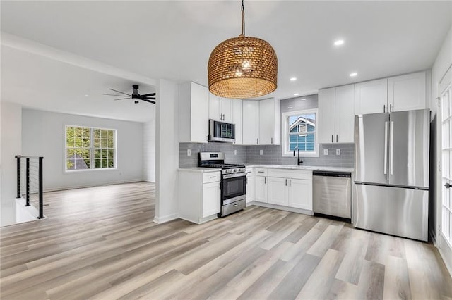 kitchen with ceiling fan, pendant lighting, sink, white cabinetry, and appliances with stainless steel finishes