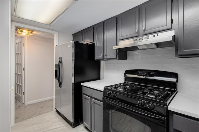 kitchen with tasteful backsplash, stainless steel fridge, and black gas range