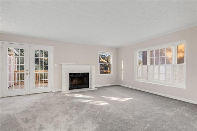 unfurnished living room with light carpet, a textured ceiling, a fireplace, and french doors