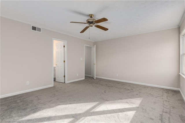 unfurnished bedroom with light carpet, crown molding, ensuite bath, and ceiling fan