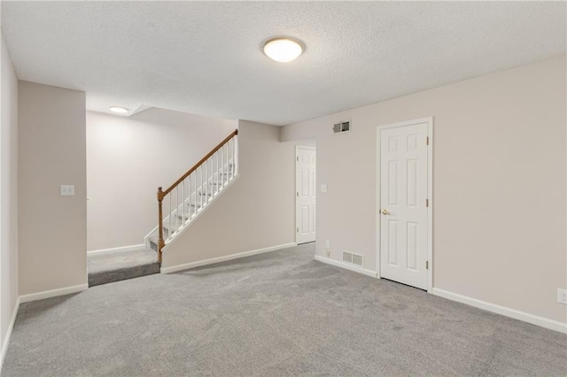 empty room featuring light colored carpet and a textured ceiling