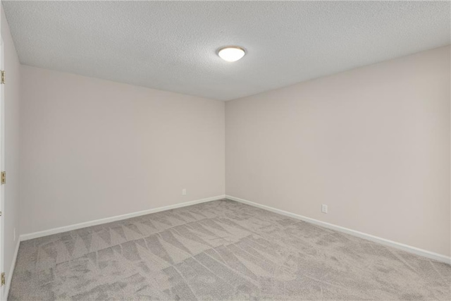 unfurnished room featuring light colored carpet and a textured ceiling