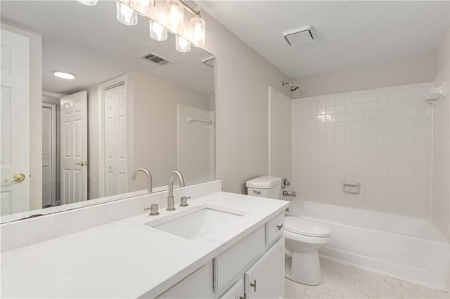 full bathroom featuring vanity, toilet, tiled shower / bath combo, and tile patterned flooring