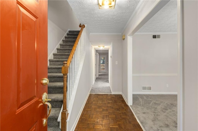 entryway featuring crown molding, dark parquet floors, and a textured ceiling