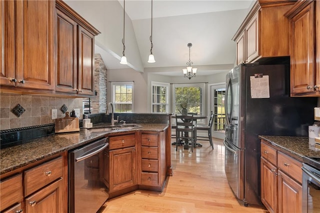 166 Woodford Way SE, Calhoun, GA 30701 - kitchen featuring appliances with stainless steel finishes, a sink, brown cabinetry, lofted ceiling, and light wood-type flooring
