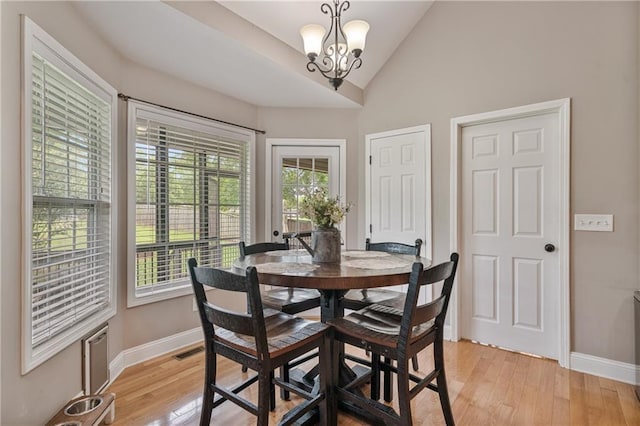 166 Woodford Way SE, Calhoun, GA 30701 - dining space with light wood-style floors, a chandelier, baseboards, and vaulted ceiling