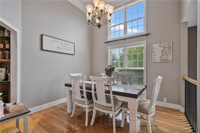 166 Woodford Way SE, Calhoun, GA 30701 - dining room with a chandelier, light wood-style floors, baseboards, and a towering ceiling