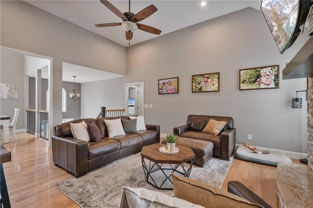 166 Woodford Way SE, Calhoun, GA 30701 - living area featuring a ceiling fan, a chandelier, light wood-style floors, a towering ceiling, and baseboards