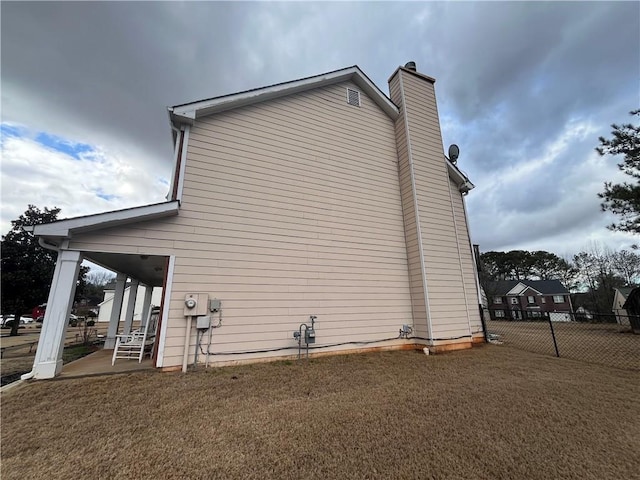 view of side of home featuring a patio and a yard