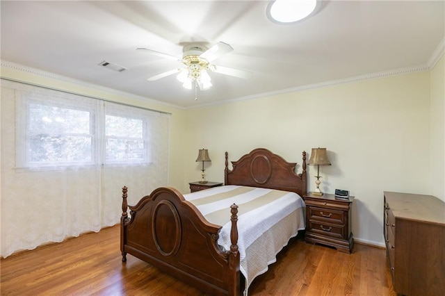 bedroom with ceiling fan, crown molding, and hardwood / wood-style flooring