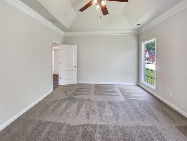 unfurnished room with ornamental molding, vaulted ceiling, a raised ceiling, ceiling fan, and carpet floors