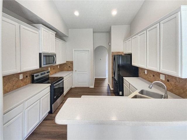 kitchen featuring dark hardwood / wood-style flooring, backsplash, stainless steel appliances, sink, and white cabinets