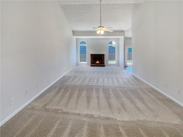 unfurnished living room featuring light colored carpet and ceiling fan