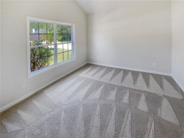 unfurnished room featuring carpet floors and vaulted ceiling