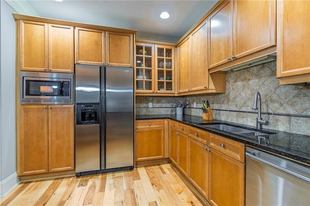 825 Highland Ln Unit 1105, Atlanta, GA 30306 - kitchen with appliances with stainless steel finishes, a sink, dark stone countertops, light wood-style floors, and backsplash
