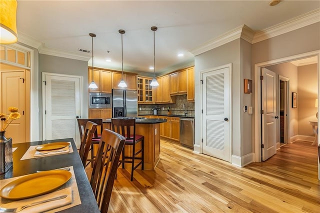 825 Highland Ln Unit 1105, Atlanta, GA 30306 - kitchen with stainless steel appliances, a sink, dark countertops, light wood-type flooring, and a center island