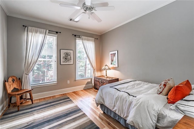 bedroom with multiple windows, light wood-type flooring, and crown molding