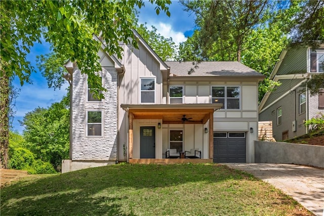 view of front of house with a garage, a front lawn, board and batten siding, concrete driveway, and ceiling fan