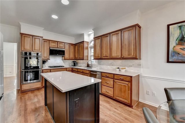 kitchen featuring light wood-type flooring, sink, stainless steel appliances, and a center island