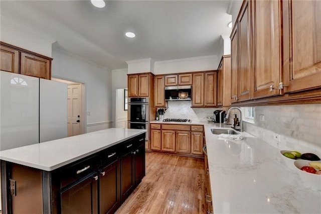 kitchen featuring tasteful backsplash, sink, stainless steel appliances, and ornamental molding