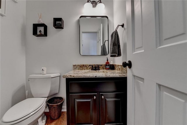 bathroom featuring hardwood / wood-style flooring, toilet, and vanity