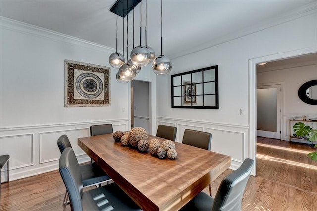 dining room with crown molding and hardwood / wood-style floors