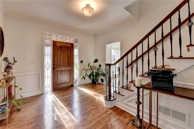 entryway with crown molding and hardwood / wood-style flooring