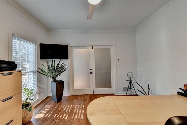 bedroom featuring ceiling fan, crown molding, hardwood / wood-style floors, and multiple windows