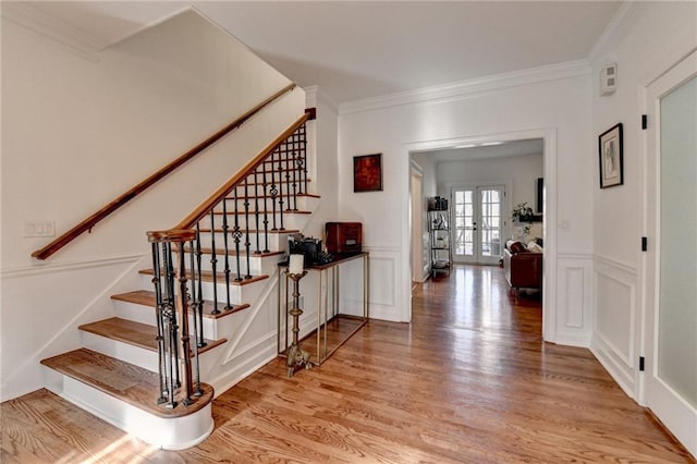 stairway featuring hardwood / wood-style flooring, ornamental molding, and french doors