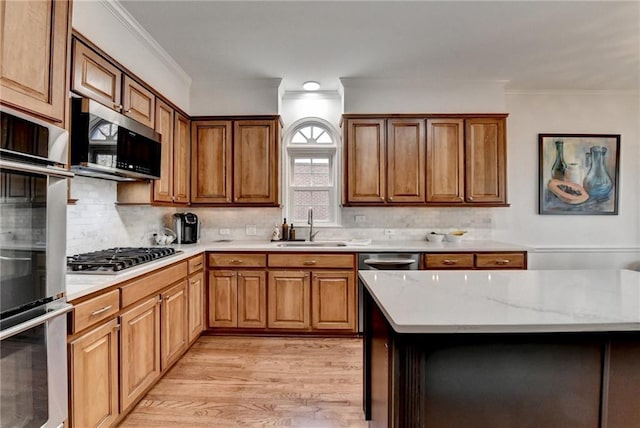 kitchen featuring light hardwood / wood-style floors, stainless steel appliances, decorative backsplash, ornamental molding, and sink