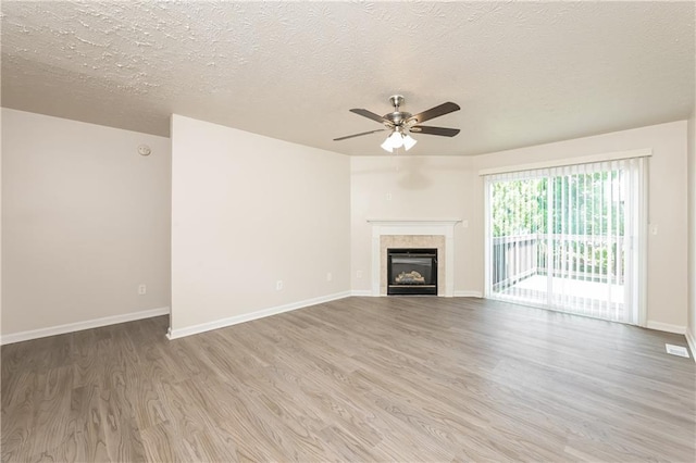 113 Garden Walk, Stockbridge, GA 30281 - unfurnished living room with wood finished floors, ceiling fan, a fireplace, and a textured ceiling