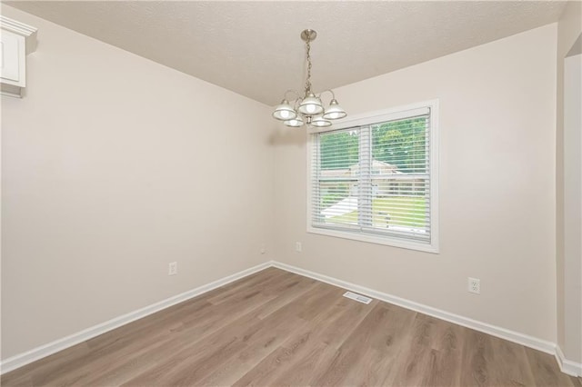 113 Garden Walk, Stockbridge, GA 30281 - spare room with light wood-style floors, a chandelier, and a textured ceiling