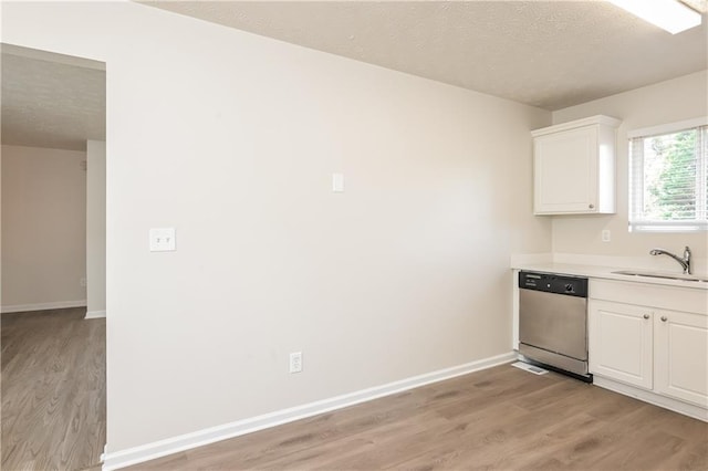 113 Garden Walk, Stockbridge, GA 30281 - kitchen with stainless steel dishwasher, light wood-style floors, a textured ceiling, light countertops, and white cabinets