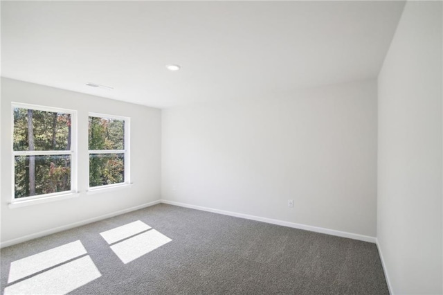 unfurnished room featuring dark carpet