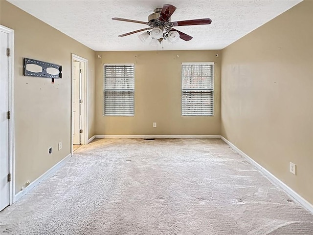 carpeted spare room with a textured ceiling, ceiling fan, and a healthy amount of sunlight