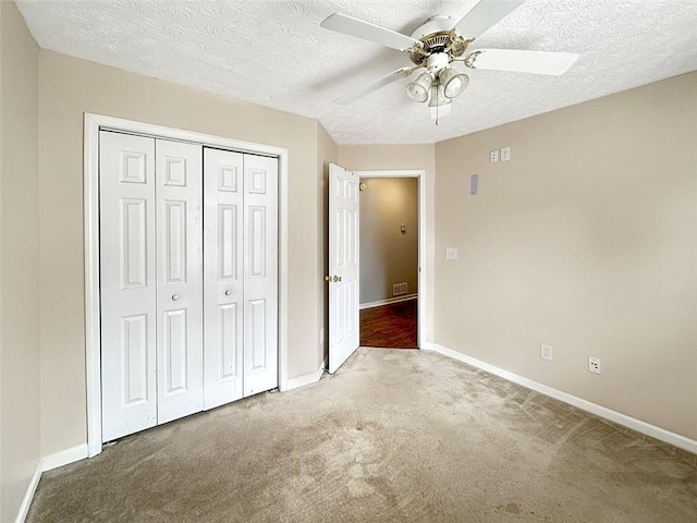 unfurnished bedroom with carpet, a textured ceiling, a closet, and ceiling fan