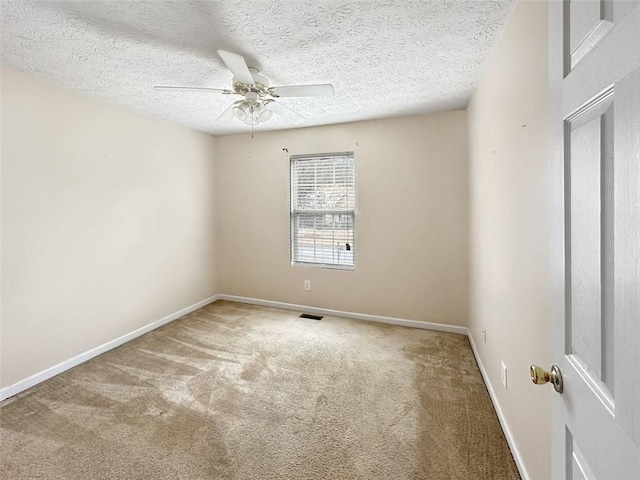 carpeted empty room with ceiling fan and a textured ceiling