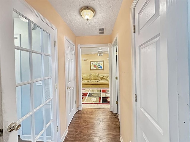 hall with dark hardwood / wood-style flooring and a textured ceiling