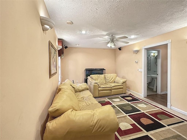 living room featuring ceiling fan and a textured ceiling