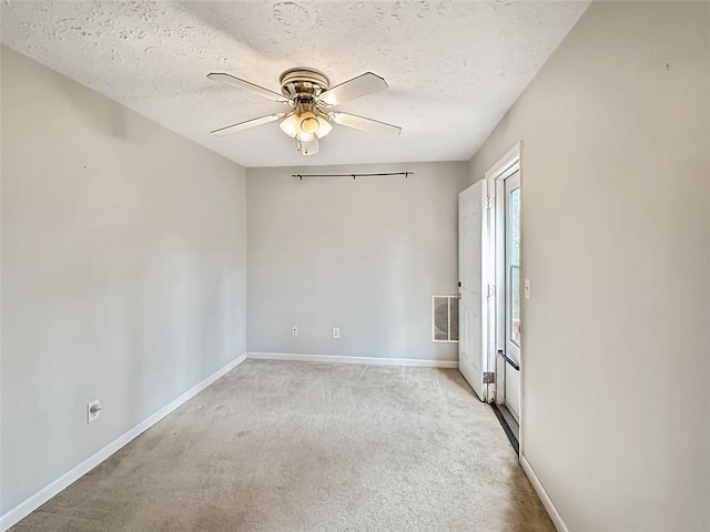 carpeted spare room featuring ceiling fan and a textured ceiling