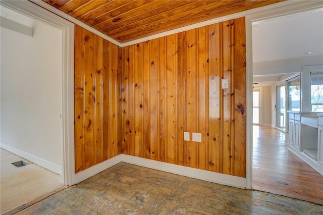 unfurnished room with wood walls, crown molding, and wooden ceiling