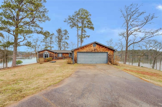 view of front of home with a front yard and a water view