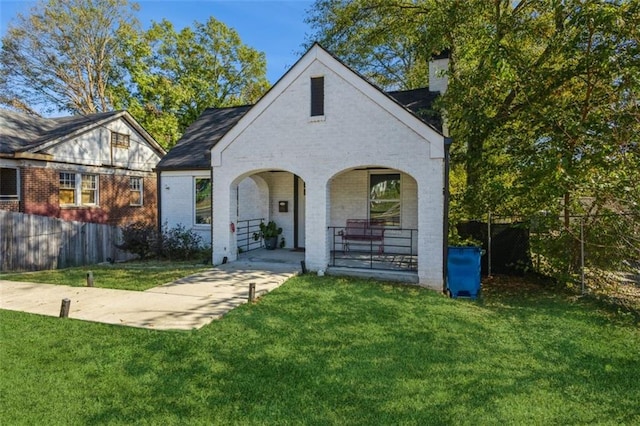 rear view of house featuring covered porch and a yard