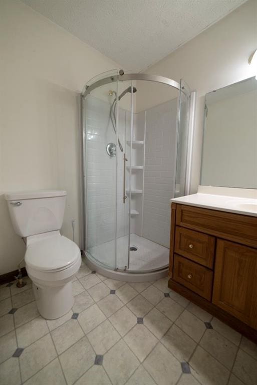 bathroom with vanity, toilet, a textured ceiling, and walk in shower