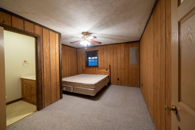 carpeted bedroom featuring ceiling fan, wooden walls, and a textured ceiling