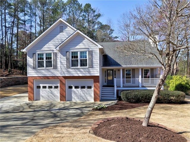 split level home with brick siding, a shingled roof, covered porch, a garage, and driveway