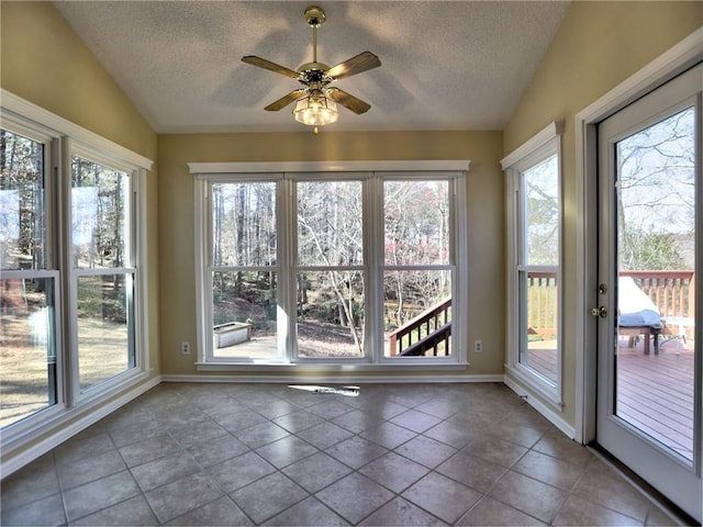 unfurnished sunroom featuring vaulted ceiling, a wealth of natural light, and ceiling fan