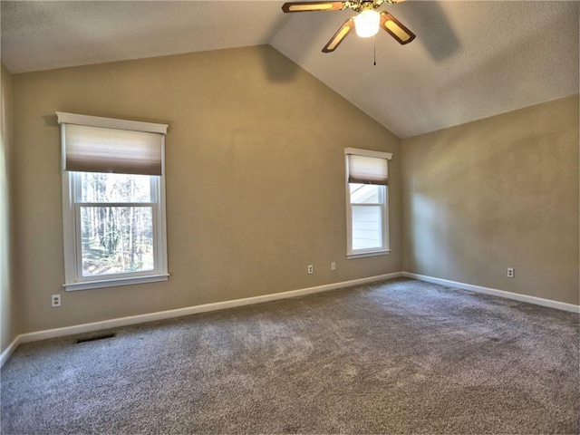 unfurnished room with a ceiling fan, carpet, visible vents, baseboards, and vaulted ceiling