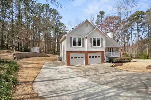 view of property exterior featuring brick siding, a porch, a chimney, driveway, and an attached garage